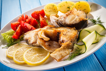 Fried fish with potatoes and vegetables