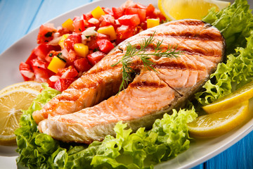 Grilled salmon with vegetables on blue wooden table