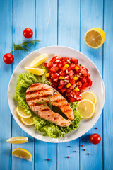 Grilled salmon with vegetables on blue wooden table