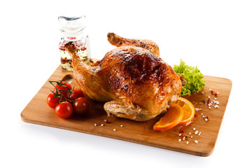 Roast chicken on cutting board on white background