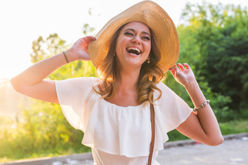 Beach woman laughing having fun in summer vacation holidays. Girl wearing big straw hat