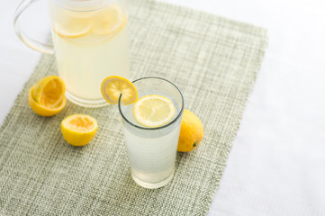 Freshly squeezed lemonade juice glass.  Lemonade is traditionally a homemade drink made with squeezed lemon, water and sugar, a simple recipe for a quick refreshing summer drink packed with vitamin c.