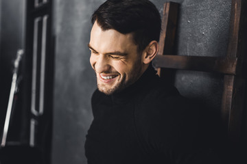 Portrait of young attractive man with muscular strong black beard, piercing sexy look in the studio posing