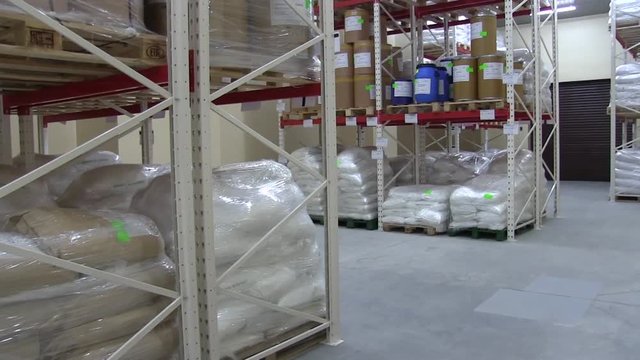 Warehouse at the Enterprise or Factory with Shelves and White Sacks and Boxes. Industrial Warehouse