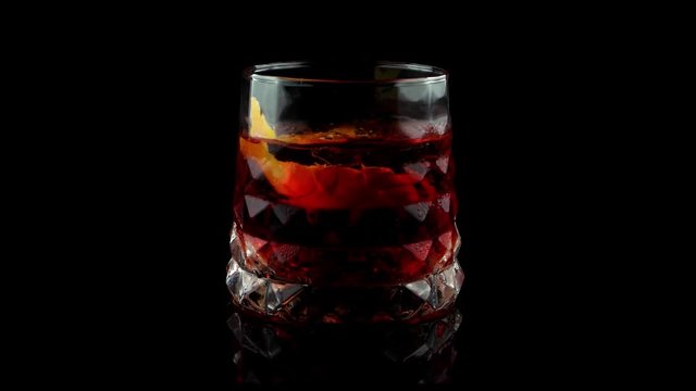 Negroni cocktail with orange peel on black background
