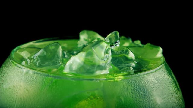 Close-up view of fresh mojito cocktail with lime, mint and ice on black background
