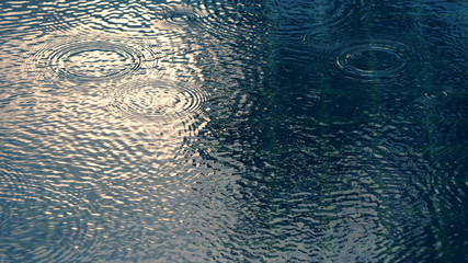 Rain drops on blue water swimming pool © gnepphoto
