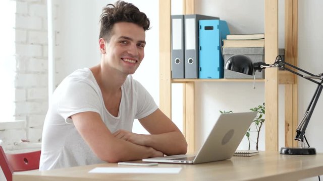 Man Working on Laptop Smiling  toward Camera