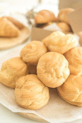 croissants and Choux Cream and Eclair on brown white table.