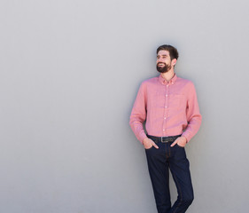 Fototapeta premium happy man standing against gray wall looking away