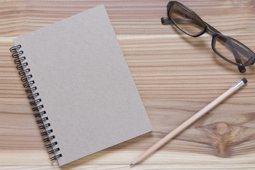 A pencil book on a brown wood floor.