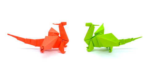 Photo of origami green and red dragons isolated on white background