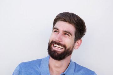 Close up smiling confident man with beard looking away and laughing