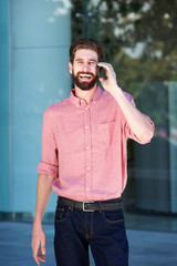 laughing man on telephone call outside in city