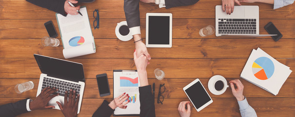 Business people group handshake in office, top view