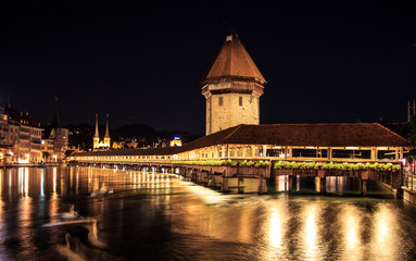 Fototapeta premium Chapel Bridge and Water Tower at night with reflection on the lake, Lucerne, Switzerland