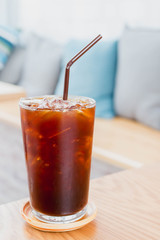 Ice coffee drink on wooden table in cafe background