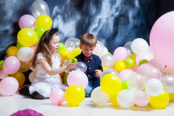 Boy and girl are playing with balloons