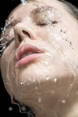Water splashes on woman's face