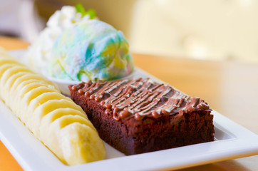 Delicious ice rainbow, brownie, cake, vanilla cream and banana in holiday.