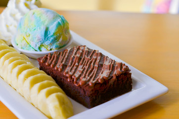 Delicious ice rainbow, brownie, cake, vanilla cream and banana in holiday.