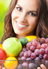 Woman with plate of fruits, outdoors