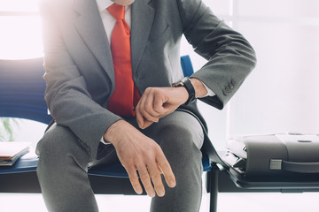 Corporate businessman waiting and checking the time
