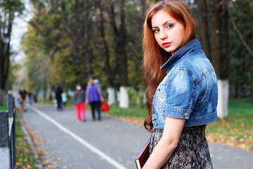 Fototapeta na wymiar red-haired girl in a park sunny day outdoor