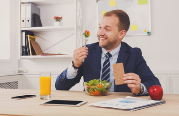 Man has healthy business lunch in modern office interior