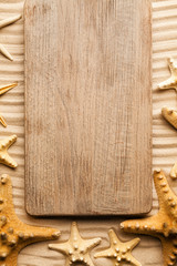 Wooden board and shells on beach