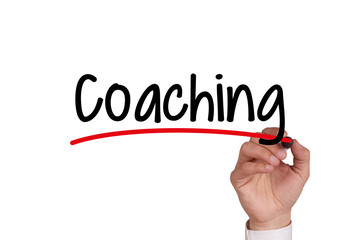 Human hand writing COACHING on whiteboard