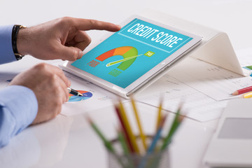 Businessman working on tablet with CREDIT SCORE on a screen