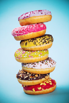 Donuts glazed with sprinkles on light blue background