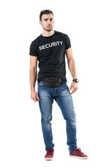 Serious confident young plainclothes officer with fanny pack looking at camera. Full body length portrait isolated on white studio background. 