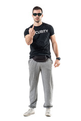 Fototapeta premium Rude bodyguard or bouncer showing middle finger obscene gesture at camera. Full body length portrait isolated on white studio background. 