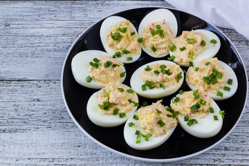 Home eggs stuffed with cheese and crab topped with green onions
