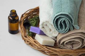 Obraz na płótnie Canvas Spa towels still life on wicker tray with essential oil bottle and natural soap