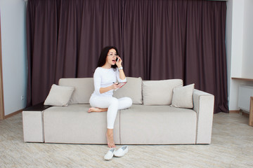 Young woman talking on mobile phone and writing notes