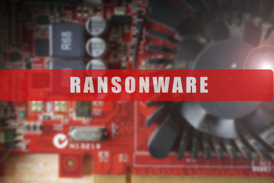 Blurred of a circuit board with big microchip . Cyber security concept with ransonware text