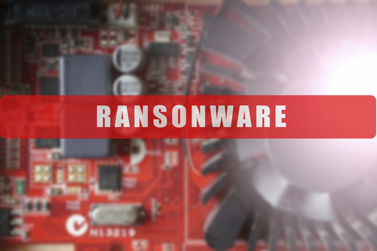 Blurred of a circuit board with big microchip . Cyber security concept with ransonware text