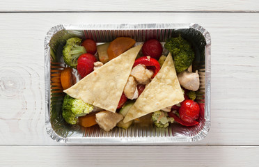 Healthy food in foil boxes, diet concept. Flatbread and salad with tomatoes