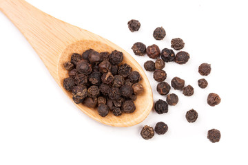Black peppercorn in a wooden spoon isolated on white background. Top view