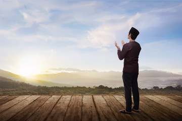 Back view of asian muslim man praying to god