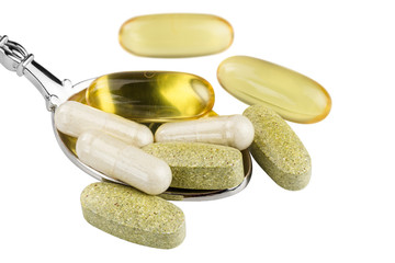 Vitamin complex, omega 3, glucosamine capsules, multivitamin supplements in the spoon isolated on...