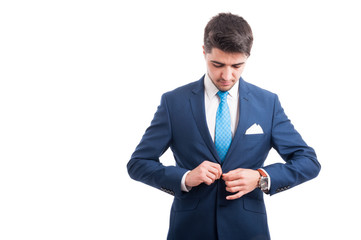 Man in stylish suit is buttoning his jacket