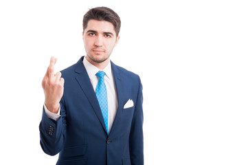 Serious young man crossing his fingers