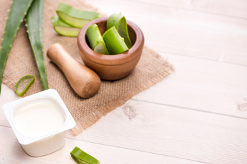 Aloe vera yogurt with fresh leaves on a wooden table