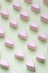 Valentines Day candy hearts marshmallows over green background