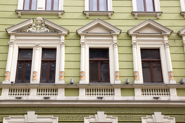 Fototapeta na wymiar Four vintage design windows on the facade of the old house