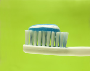 toothbrush with toothpaste on yellow background